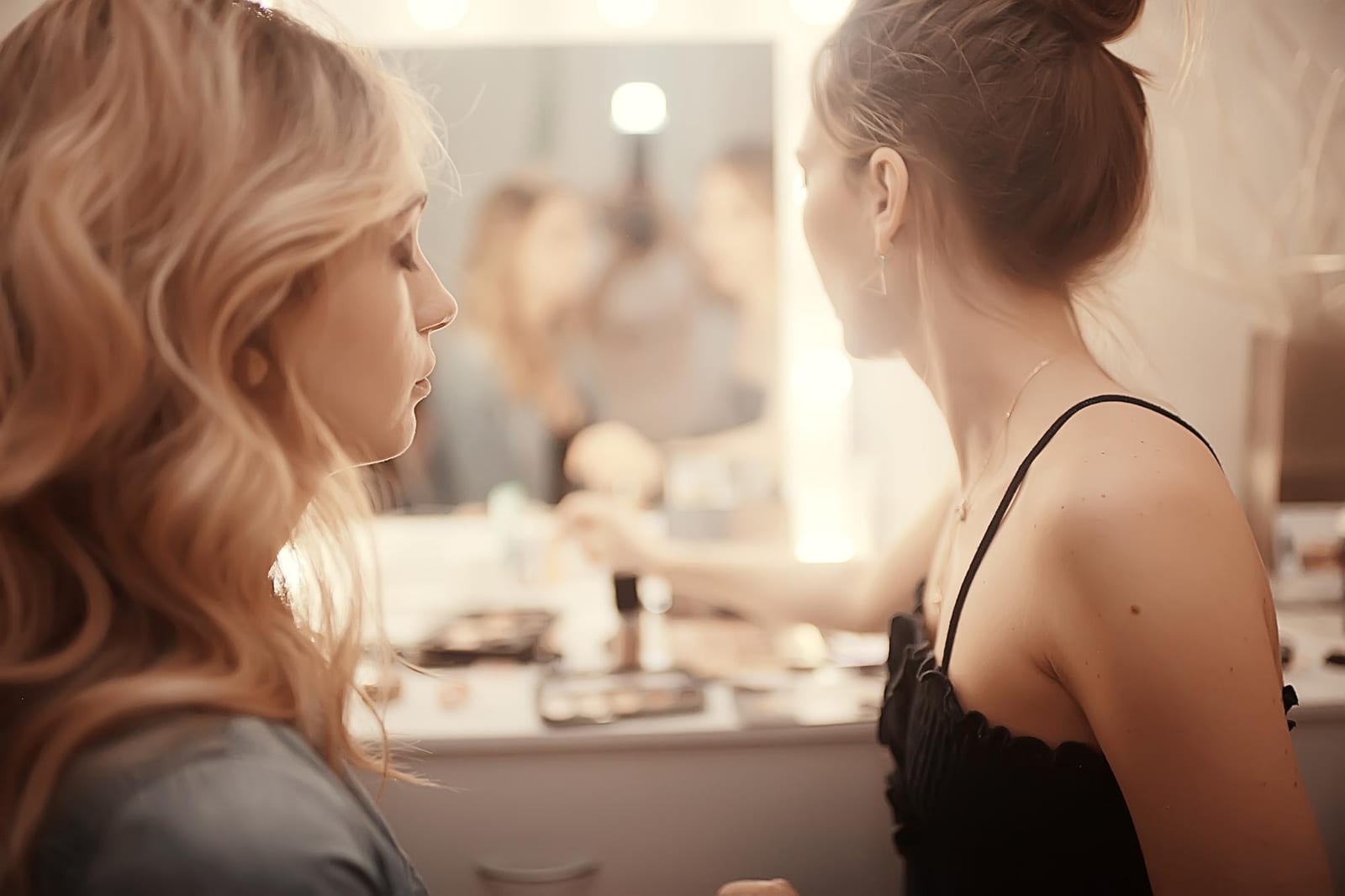 Duas mulheres conversam em frente a um espelho de salão